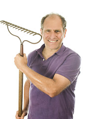 Image showing middle age senior man holding garden bow rake tool