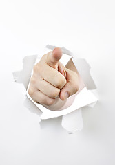 Image showing Finger pointing through hole in paper