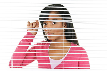 Image showing Woman looking through venetian blinds