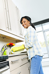 Image showing Happy young woman washing dishes