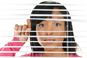 Image showing Woman looking through venetian blinds