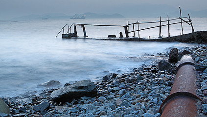 Image showing old metal pipe and road to sea