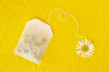 Image showing nBag of chamomile tea over yellow handmade paper - concept