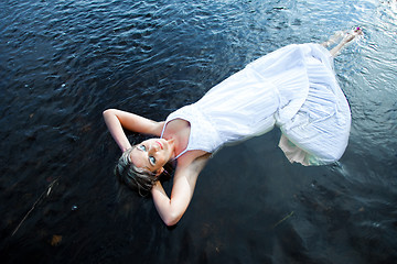 Image showing beautiful woman floating in blue river