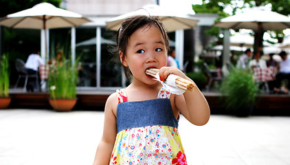 Image showing Young Asian girl having a snack