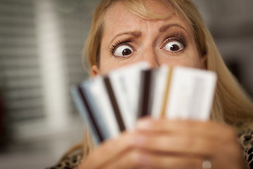 Image showing Upset Woman Glaring At Her Many Credit Cards