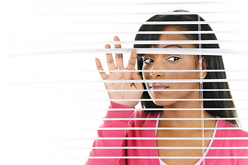 Image showing Woman looking through venetian blinds