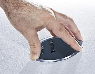 Image showing Hands installing metal pot light fixture