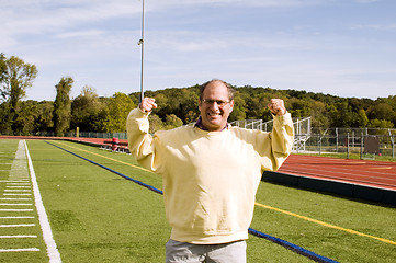 Image showing middle age senior man stretching exercising on sports field