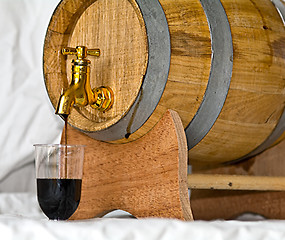 Image showing Pouring up a glass of nocino, from a barrel