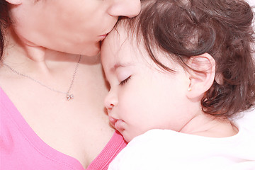 Image showing delighted young mother taking care of her adorable baby at home