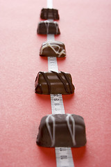 Image showing Some of chocolates and the measure