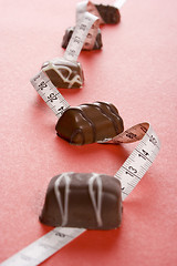 Image showing Some of chocolates and the measure