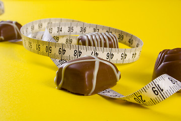 Image showing Some of chocolates and the measure