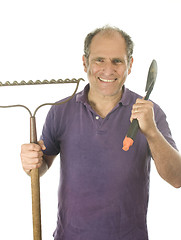 Image showing middle age senior man gardener with spade and  bow rake tools