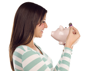 Image showing Ethnic Female Putting Coin Into Piggy Bank on White