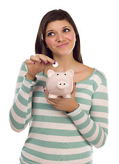 Image showing Ethnic Female Putting Coin Into Piggy Bank on White