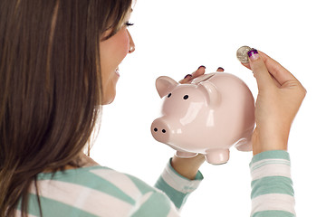 Image showing Ethnic Female Putting Coin Into Piggy Bank on White