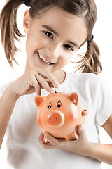 Image showing Little girl with a piggy-bank