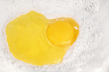Image showing Broken eggs  in the flour