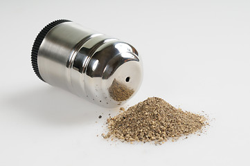 Image showing Pepper shaker and spilled pepper