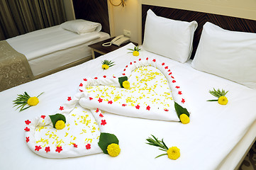 Image showing Bed Suite decorated with flowers and towels.