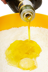 Image showing Oil flowing  to  the broken egg in the flour