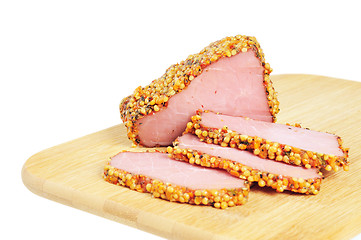 Image showing Piece of a ham with spices on a wooden board