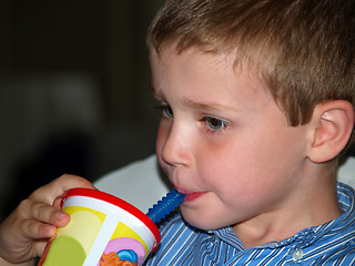 Image showing boy at restaurant drinking through a straw