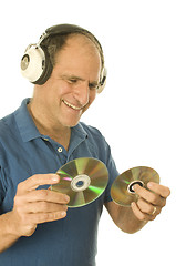 Image showing middle age senior man listening to music through classic head ph