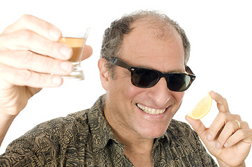 Image showing middle age senior tourist male sun glasses  drinking tequila sho