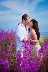 Image showing Romantic kiss among purple flowers