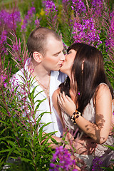 Image showing Romantic kiss among purple flowers