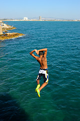 Image showing Teens, jumping into the sea.