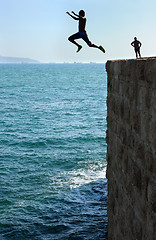 Image showing Teens, jumping into the sea.