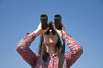 Image showing Young woman using binoculars 