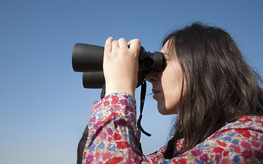 Image showing Young woman using binoculars 