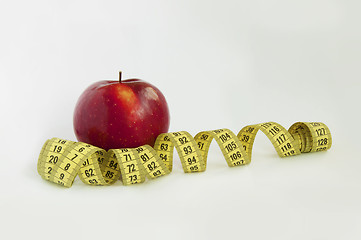 Image showing Ð•xtended tape Measure with red Apple