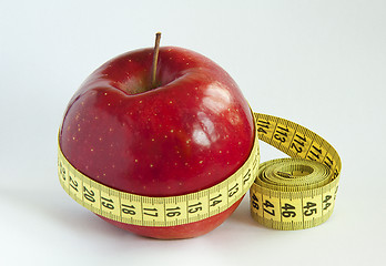 Image showing Yellow tape Measure with red Apple