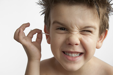 Image showing Boy cleans his ear