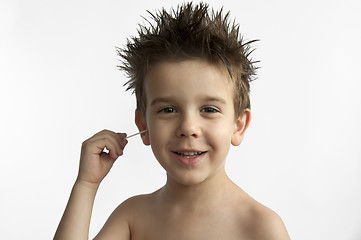 Image showing Boy cleans his ear