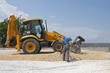 Image showing Worker and gravel excavator