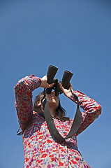 Image showing Young woman using binoculars 