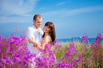 Image showing Romantic couple among purple flowers near blue sea