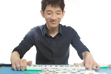 Image showing Chinese man play Mahjong, traditional China gamble. 