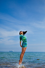 Image showing beautiful girl jumping out of sea 