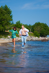 Image showing Enamored couple running along the coast of sea