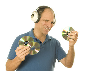 Image showing senior man listening to music cd discs with vintage head phones 