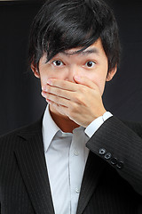 Image showing scared adult man with hand covering mouth 