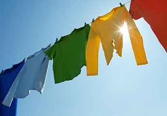 Image showing Colorful clothes on a laundry line and sun shining